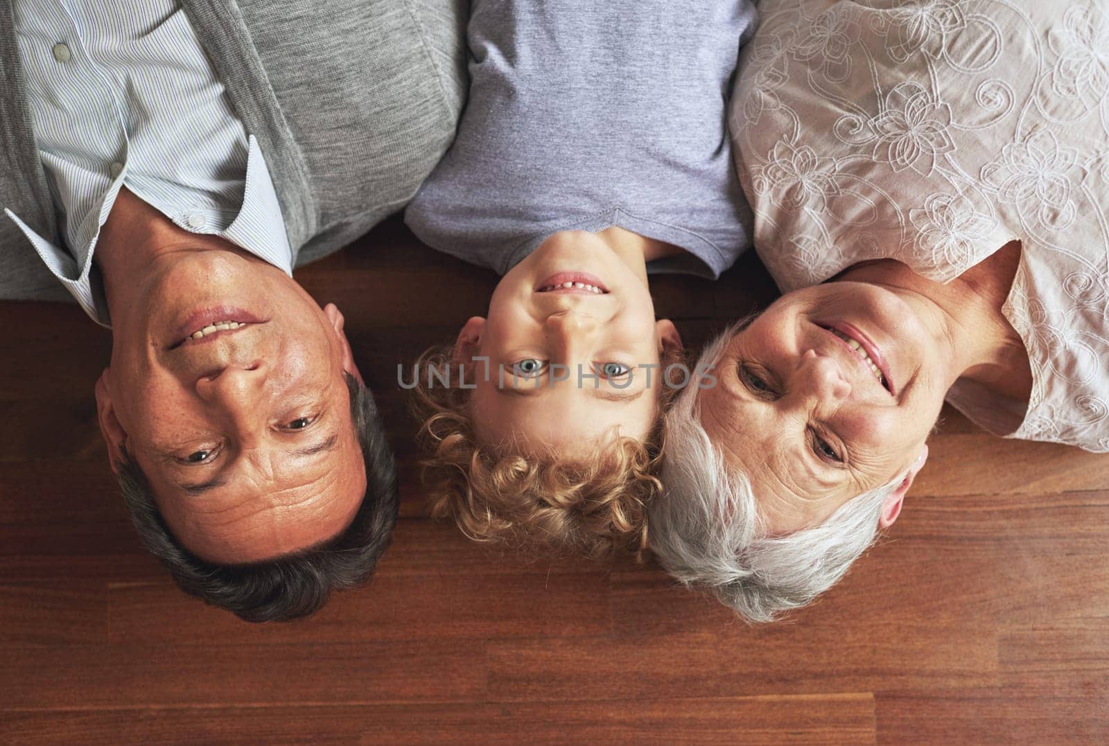 Portrait, grandparents and boy on the floor, love and bonding together with joy or apartment. Family, face or old man with elderly woman, kid or grandchild with fun or cheerful with home or vacation.