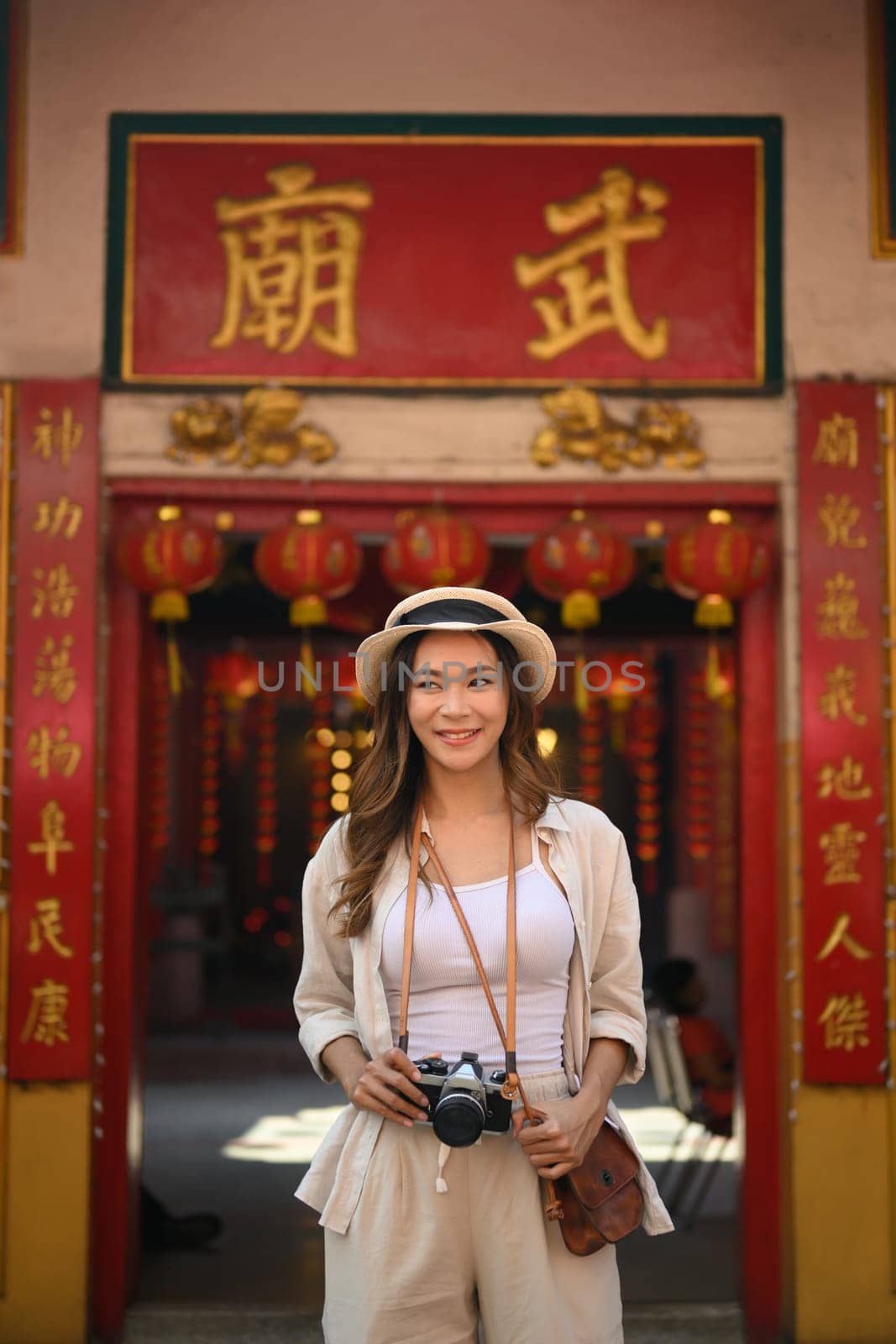 Portrait of beautiful female traveller standing at a Chinese Temple locating in the downtown.