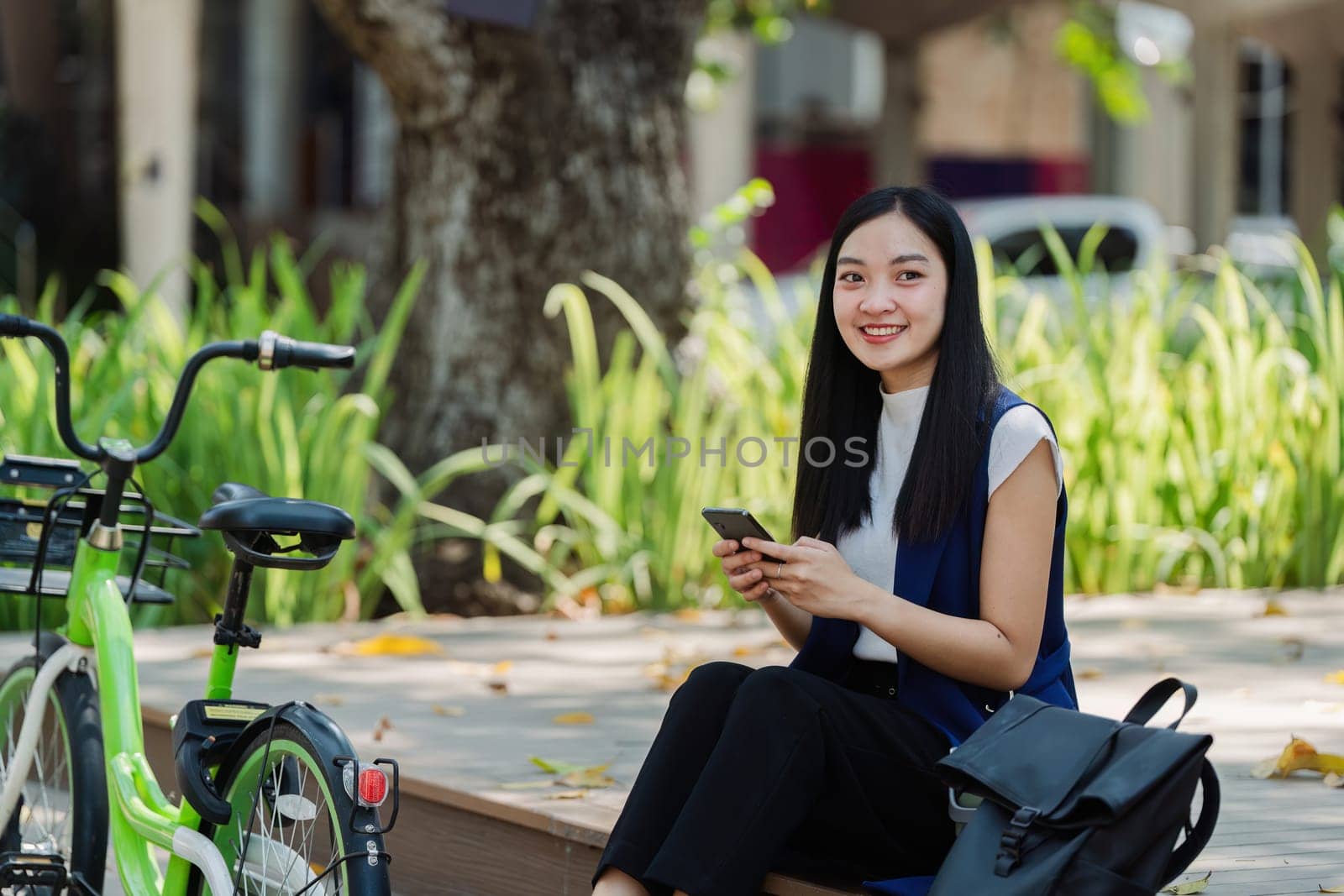 asian young businesswoman use smart phone while commuting in city. Eco friendly by itchaznong