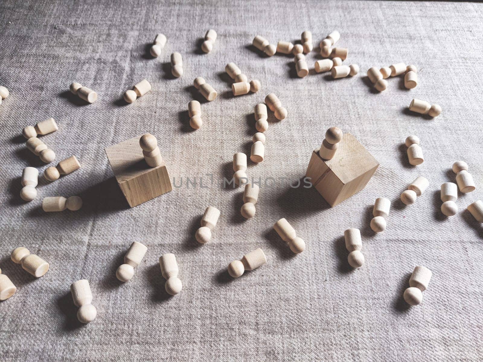 Wooden toys stand opposite and lot of lying figures. Concept of dispute between leaders of two groups. Government and deaths of citizens and soldiers. War in Russia, Ukraine, Israel, Palestine