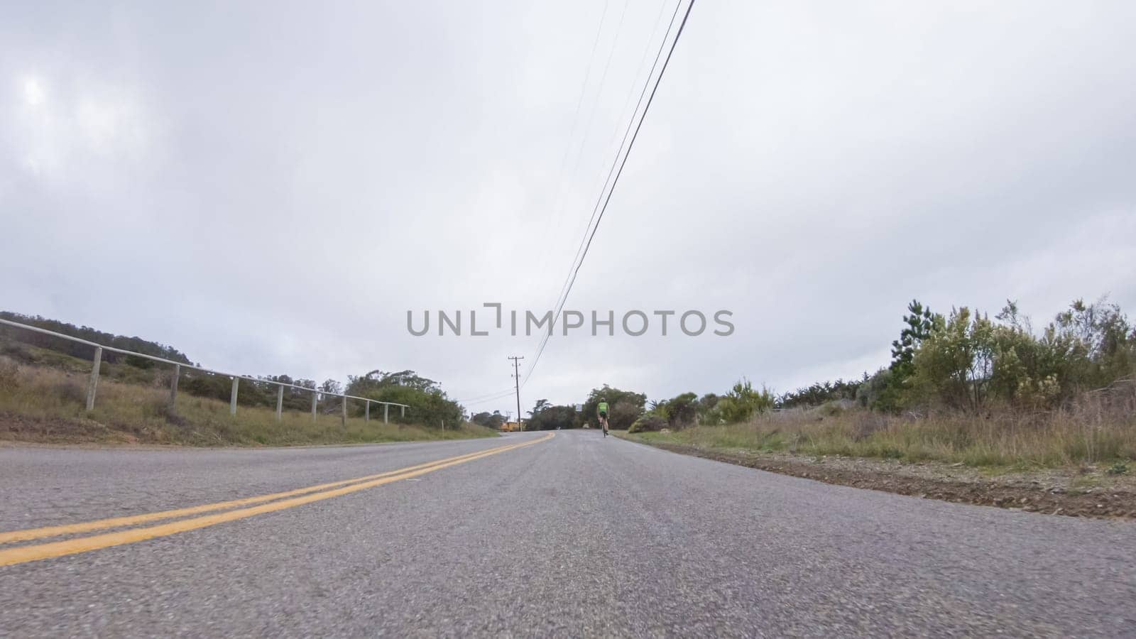 Vehicle navigates the streets of Morro Bay, California, during a cloudy winter day. The atmosphere is moody and serene as the overcast sky casts a soft light on the charming buildings and quiet streets of this coastal town.