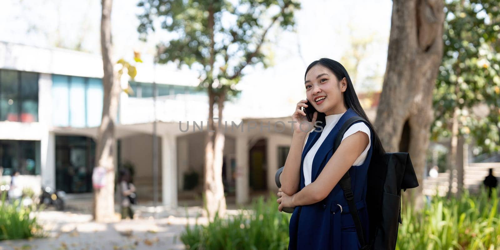 Young happy Asian business woman office professional talk cellphone in walking on city go work.