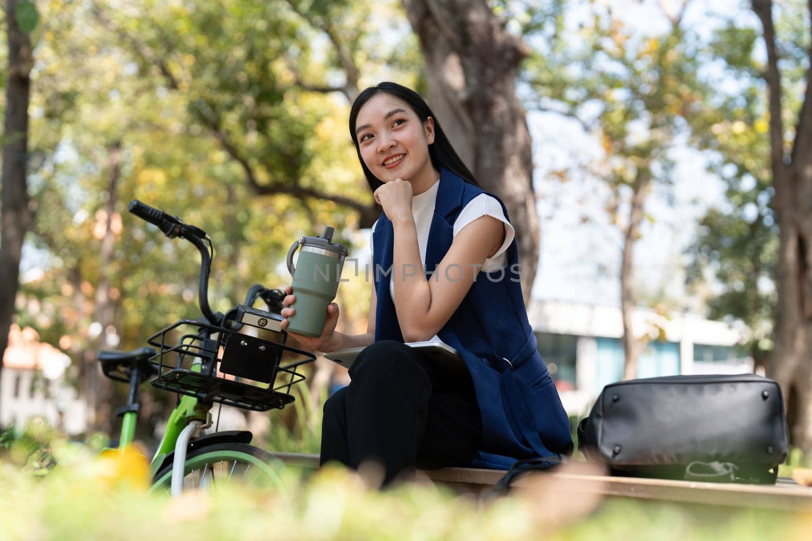 Businesswoman ride bicycle sit outside working Entrepreneur commuting by cycling reduce carbon footprint. Bike to work eco friendly alternative vehicle green energy.