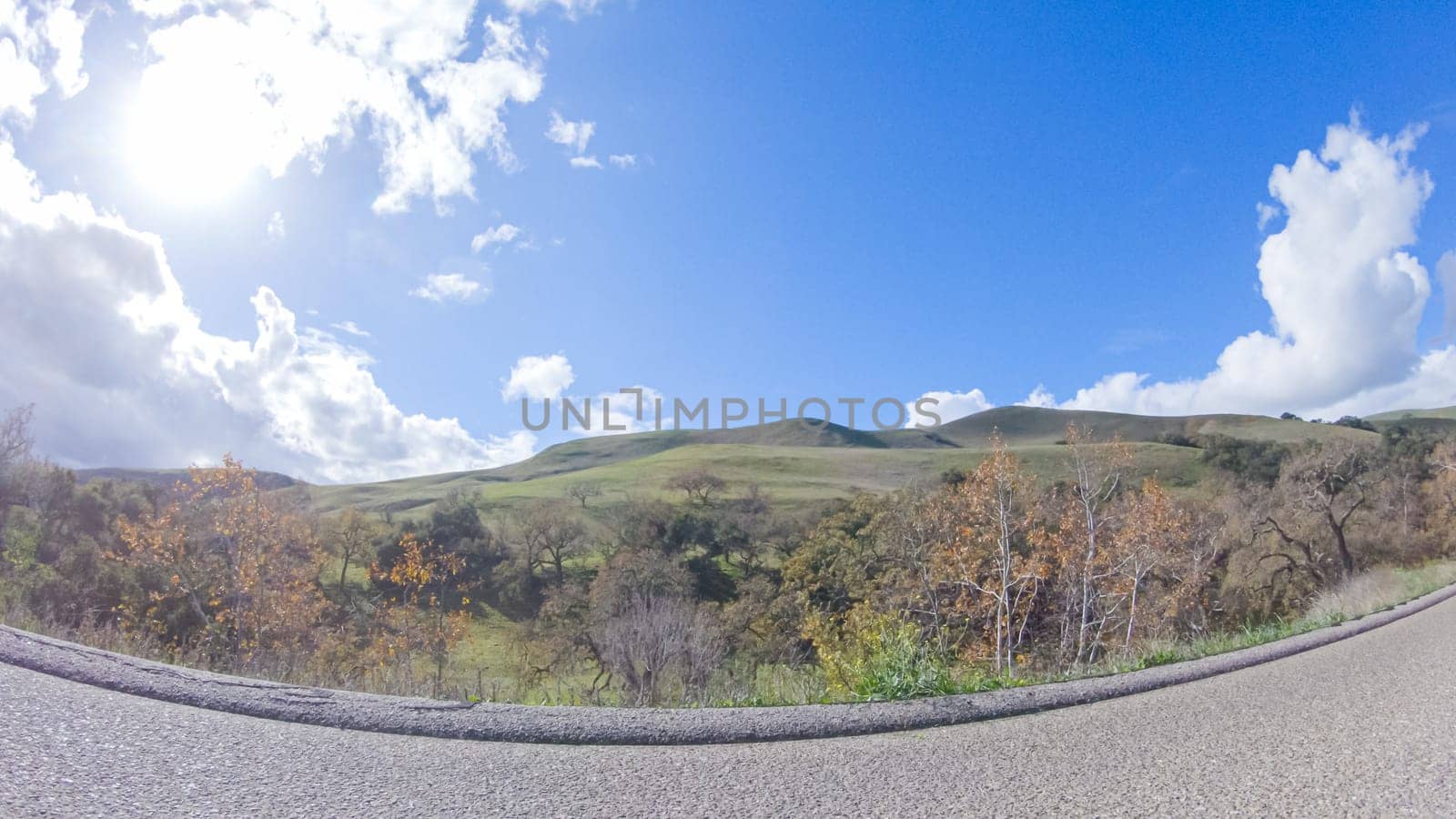 Vehicle is cruising along the Cuyama Highway under the bright sun. The surrounding landscape is illuminated by the radiant sunshine, creating a picturesque and inviting scene as the car travels through this captivating area.