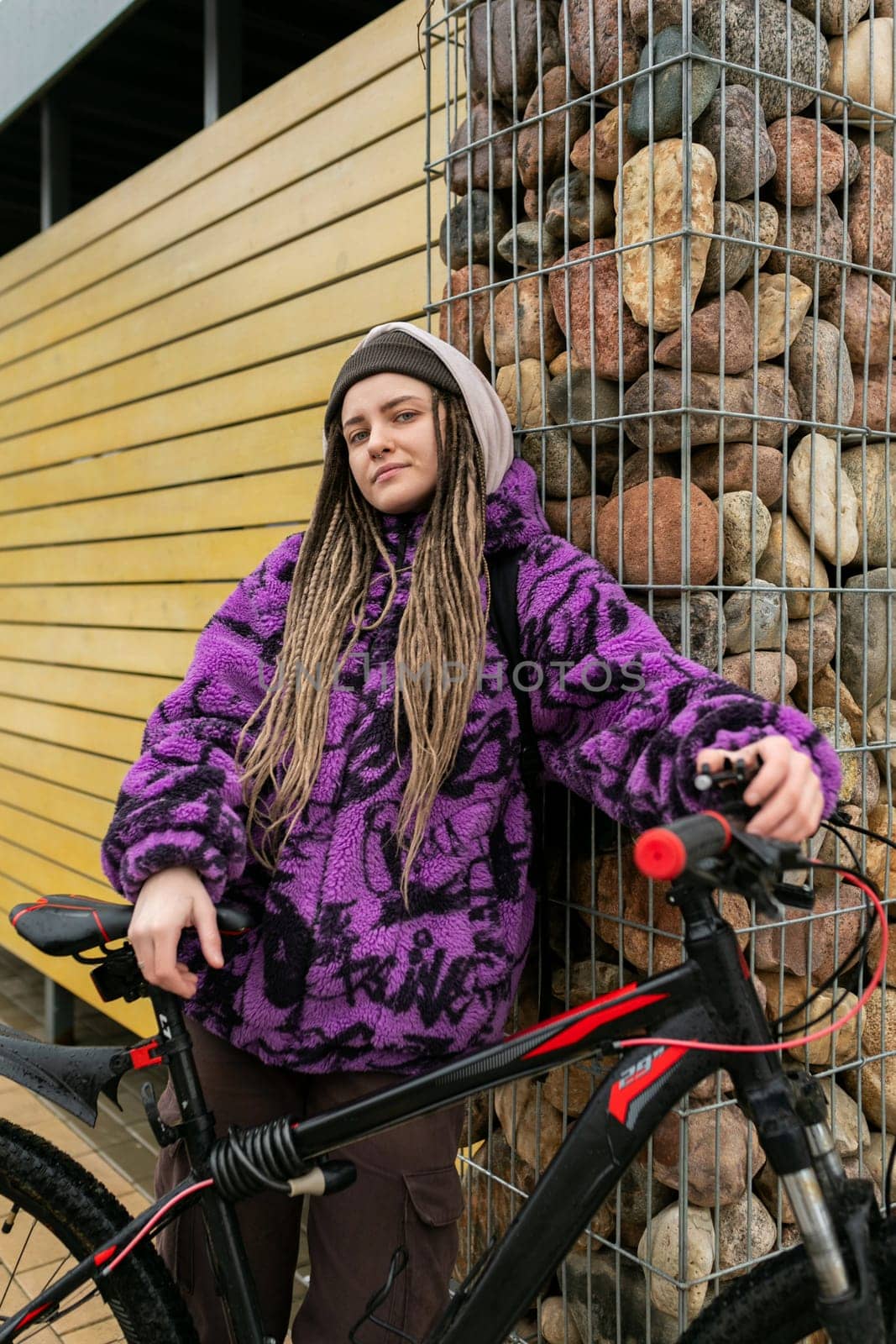 Cute young woman with piercings and dreadlocks rented a bike around the city.