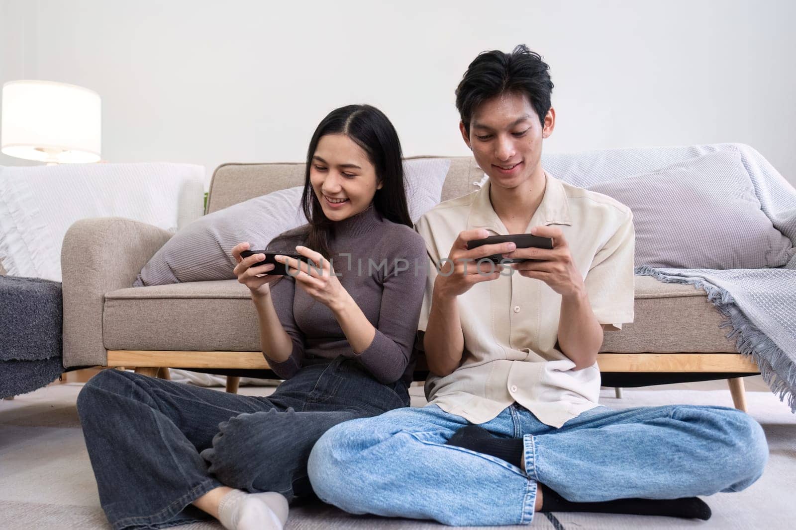 A young Asian couple spends their free time relax together in the living room on vacation..