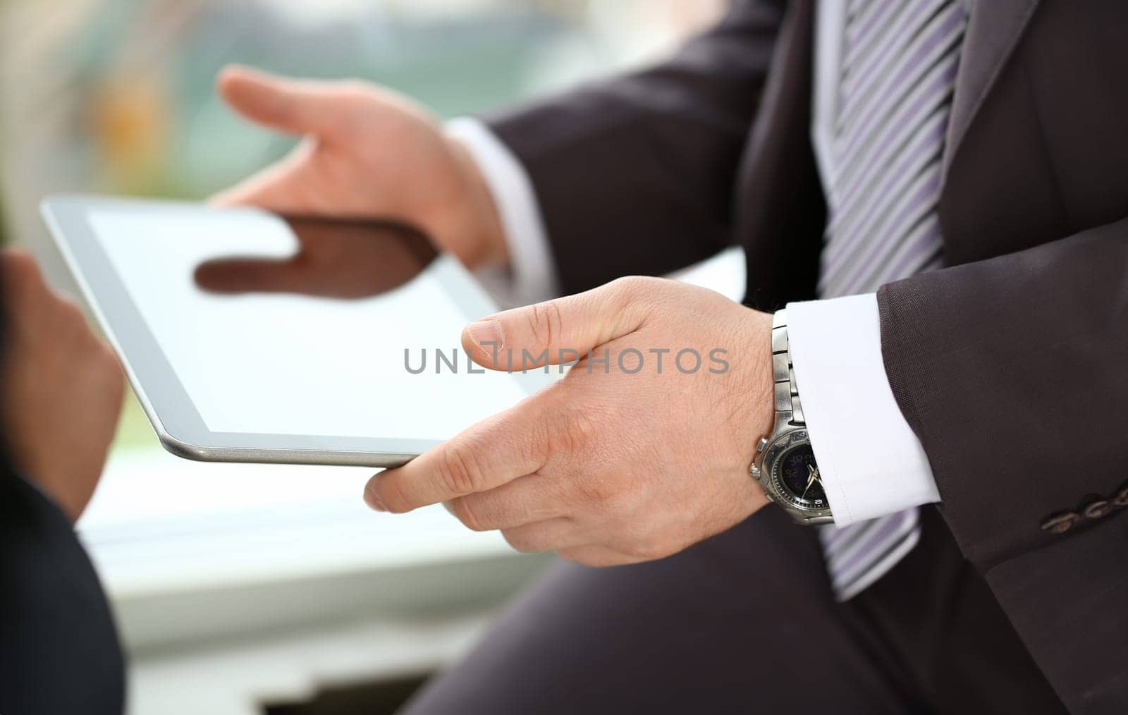 Two businessman are looking and studying statistics on tablet display closeup. Male hand opponent holds pen and points out problem collaboration business coach cooperation partnership palm concept