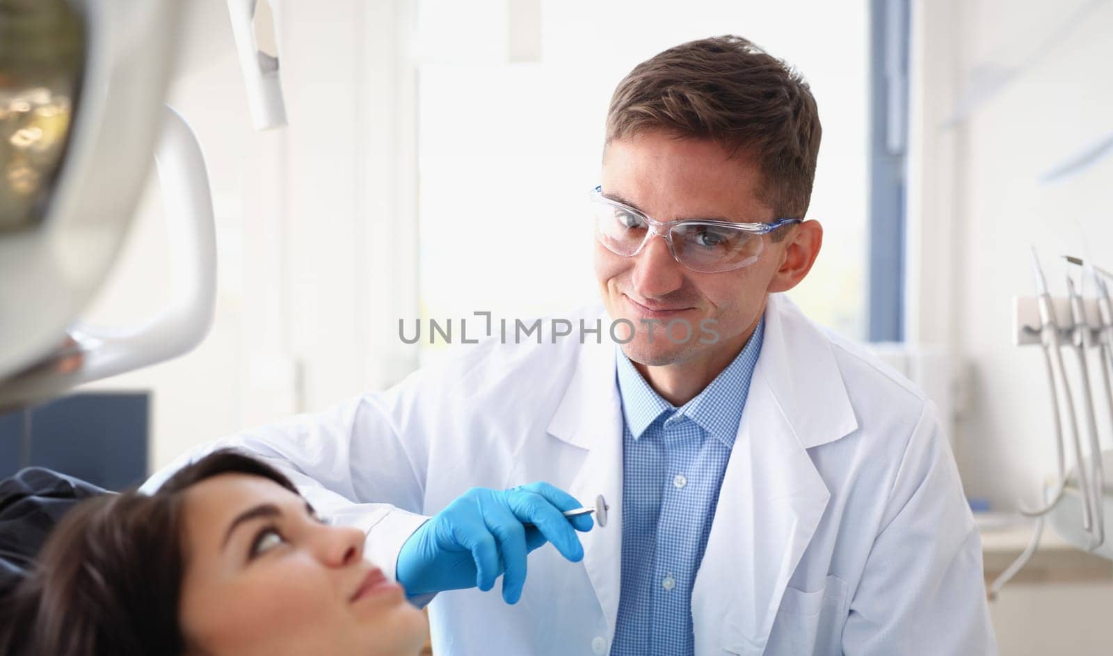 A woman at the reception of a male dentist examining by kuprevich