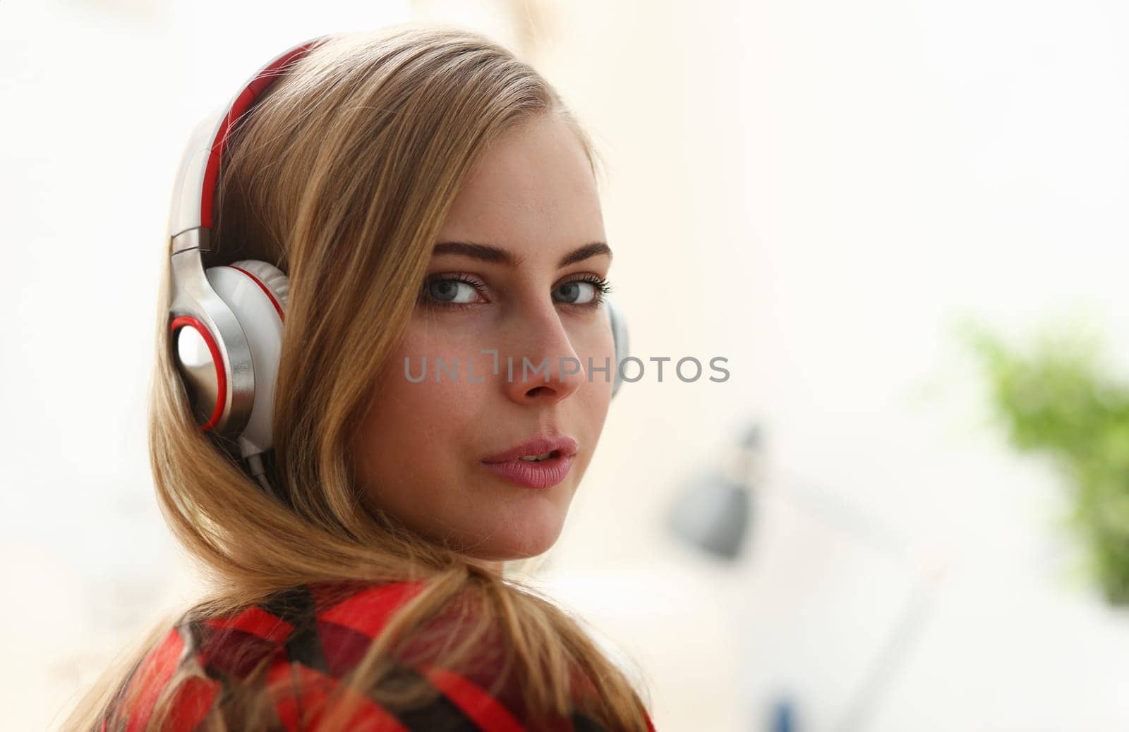 young blond woman portrait lie on sofa listen music dream pleasure concept