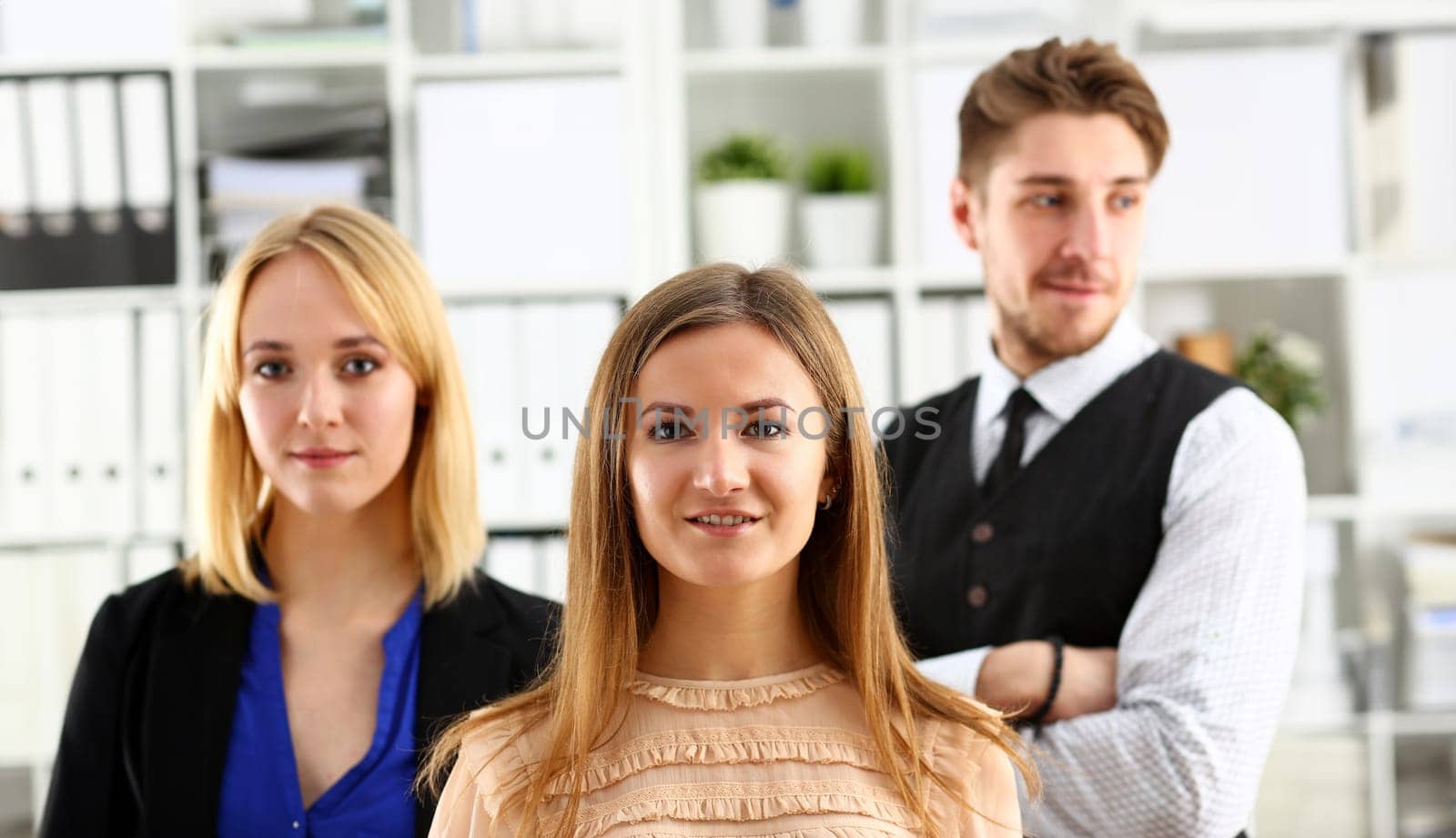 Group of smiling people stand in office looking in camera by kuprevich
