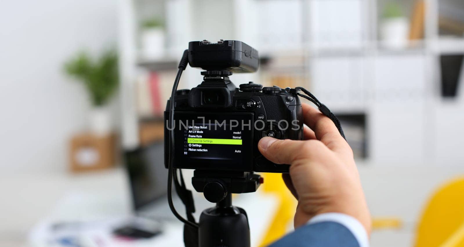 Male arms in suit mount camcorder to tripod making promo videoblog or photo session in office closeup. Vlogger adjust set up and check image quality to show job offer promotion selfie information