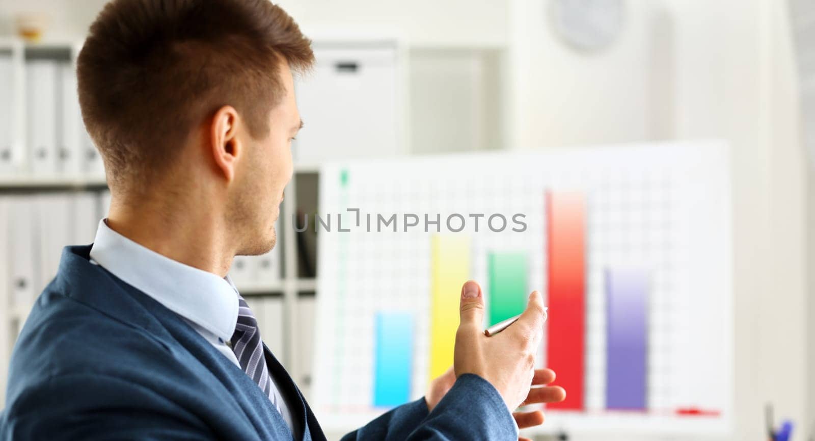 Man in suit point with arm in stats graph in office closeup. Stock exchange market advisor sale examination industry profit research occupation account career present ambition negotiation study trade