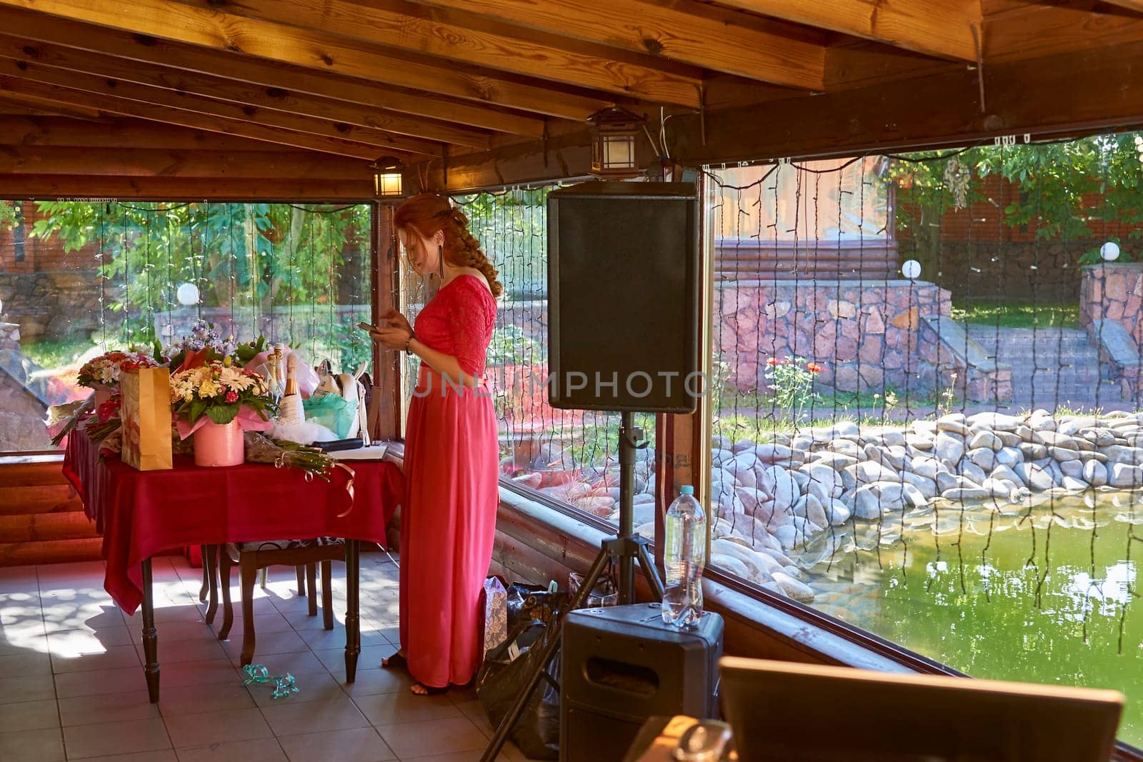 Birthday, wedding and event host in red scarlet dress waiting for guests by jovani68