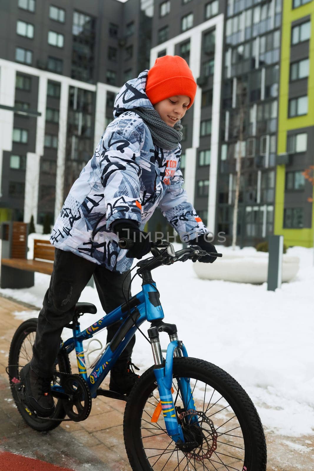 A male child rides a sports bike in the cold season.