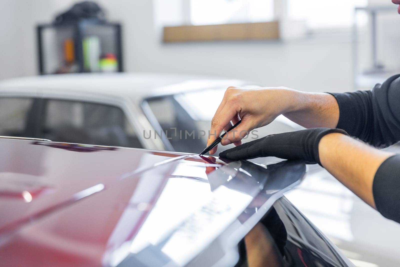 Process of gluing or wrapping a new foil wrap to a car, car detailing concept by Kadula