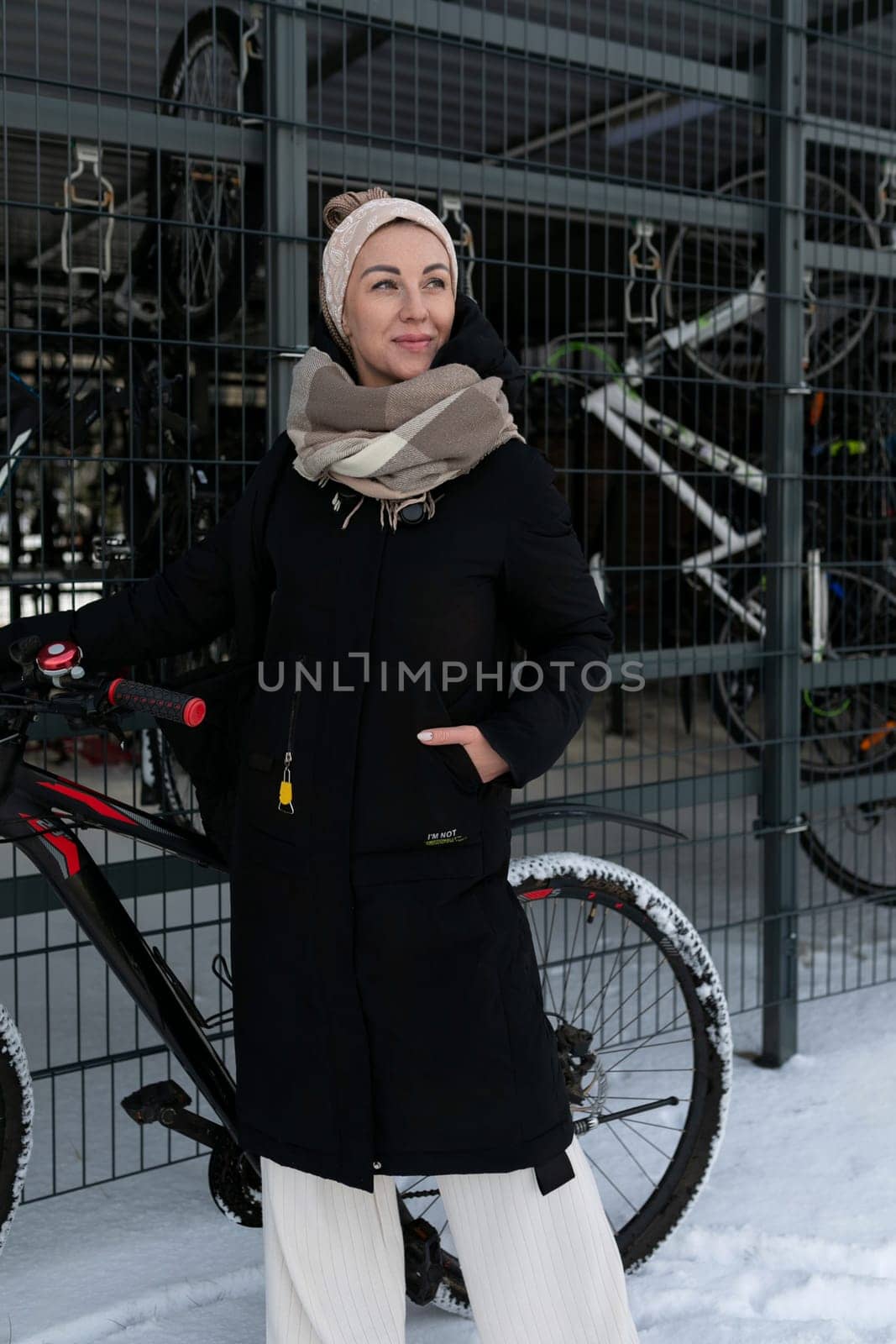 Smiling cute woman with blond dreadlocks rented a bicycle in winter.