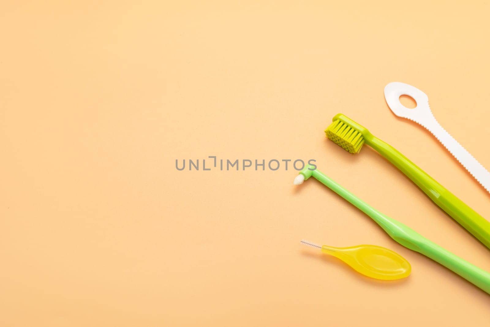 Design Individual Dental Oral Hygiene Set Kit. Dentistry White Tongue Scraper, Toothbrush, Interdental Toothbrush For Cleaning Between Teeth On Peach Yellow Background. Copy Space Horizontal Plane