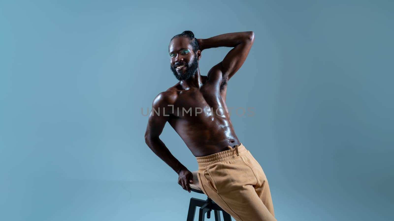 Shirtless black gay model posing on stool in blue studio by andreonegin