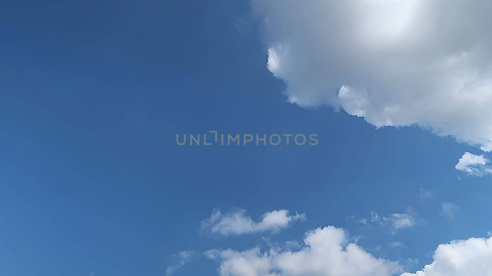 Heavenly white clouds on the blue sky with the sun appeared perfect for multimedia texture or background and content creation