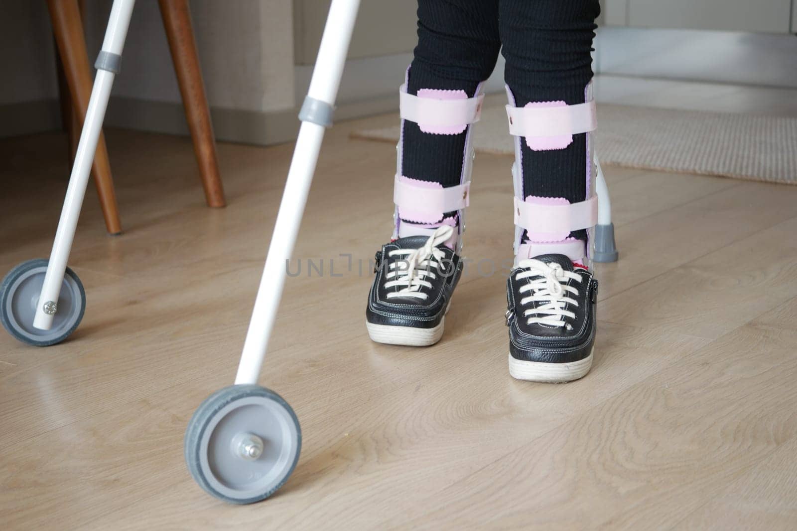 child with walking frame and knee orthosis outdoor by towfiq007