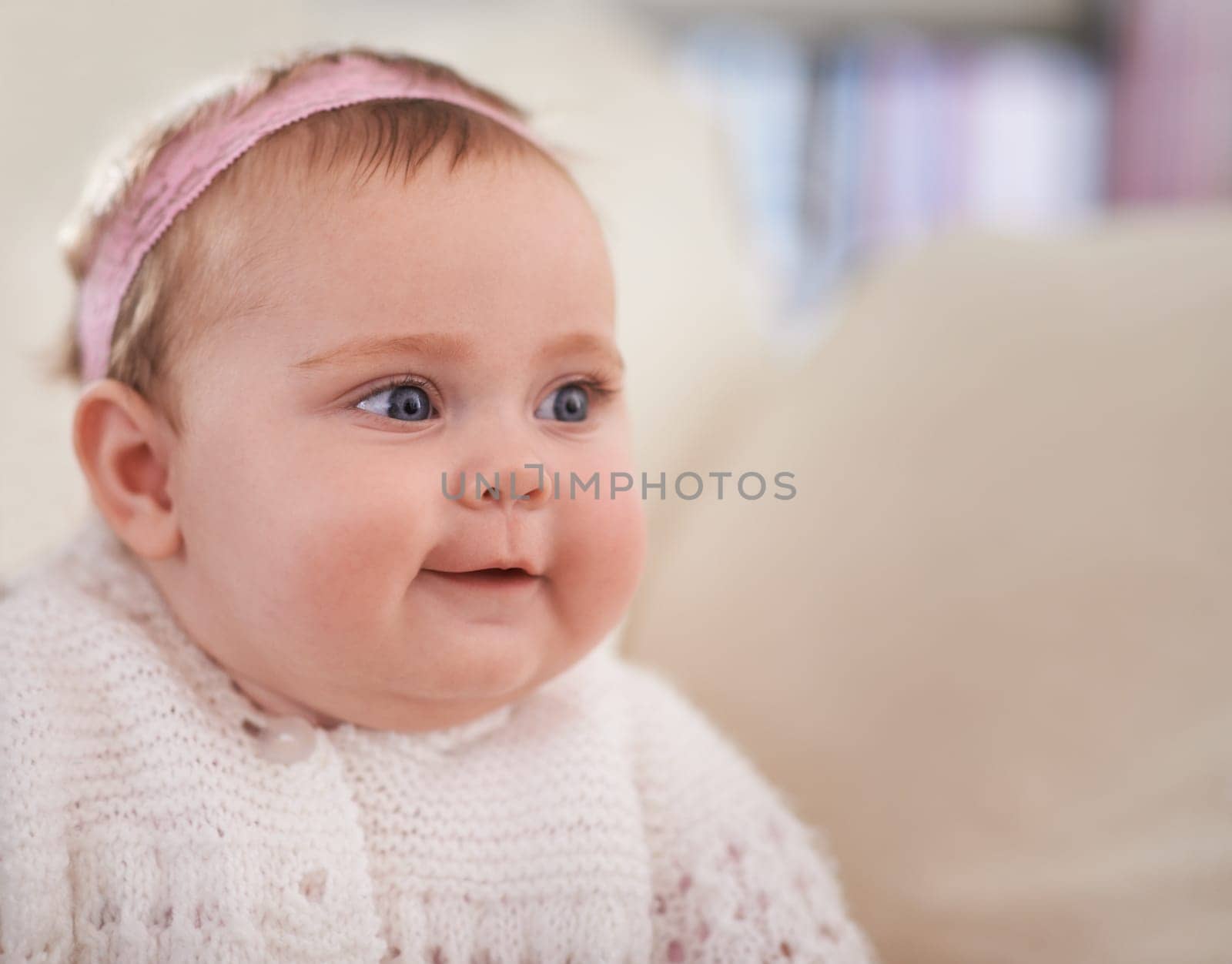 Happy, baby and face in a home with a calm, relax and sweet infant in a living room. Youth, child and house with toddler clothing in the morning ready for a nap on the sofa with joy and headband.