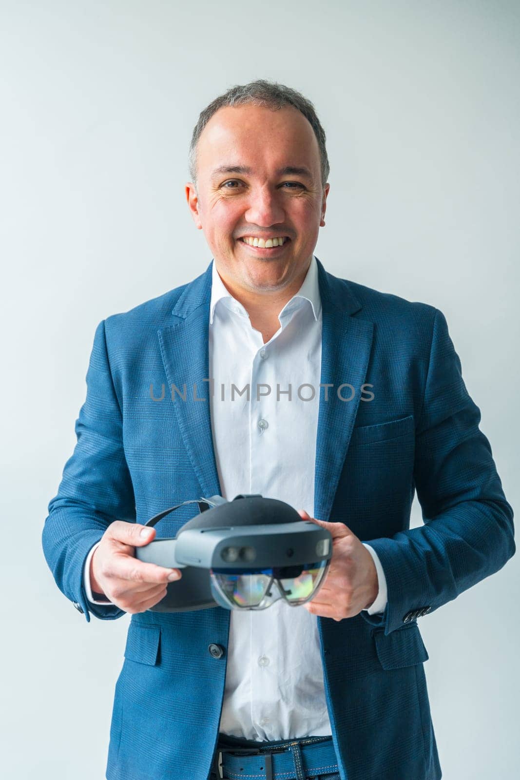 Businessman holding a futuristic mixed reality goggles by Huizi
