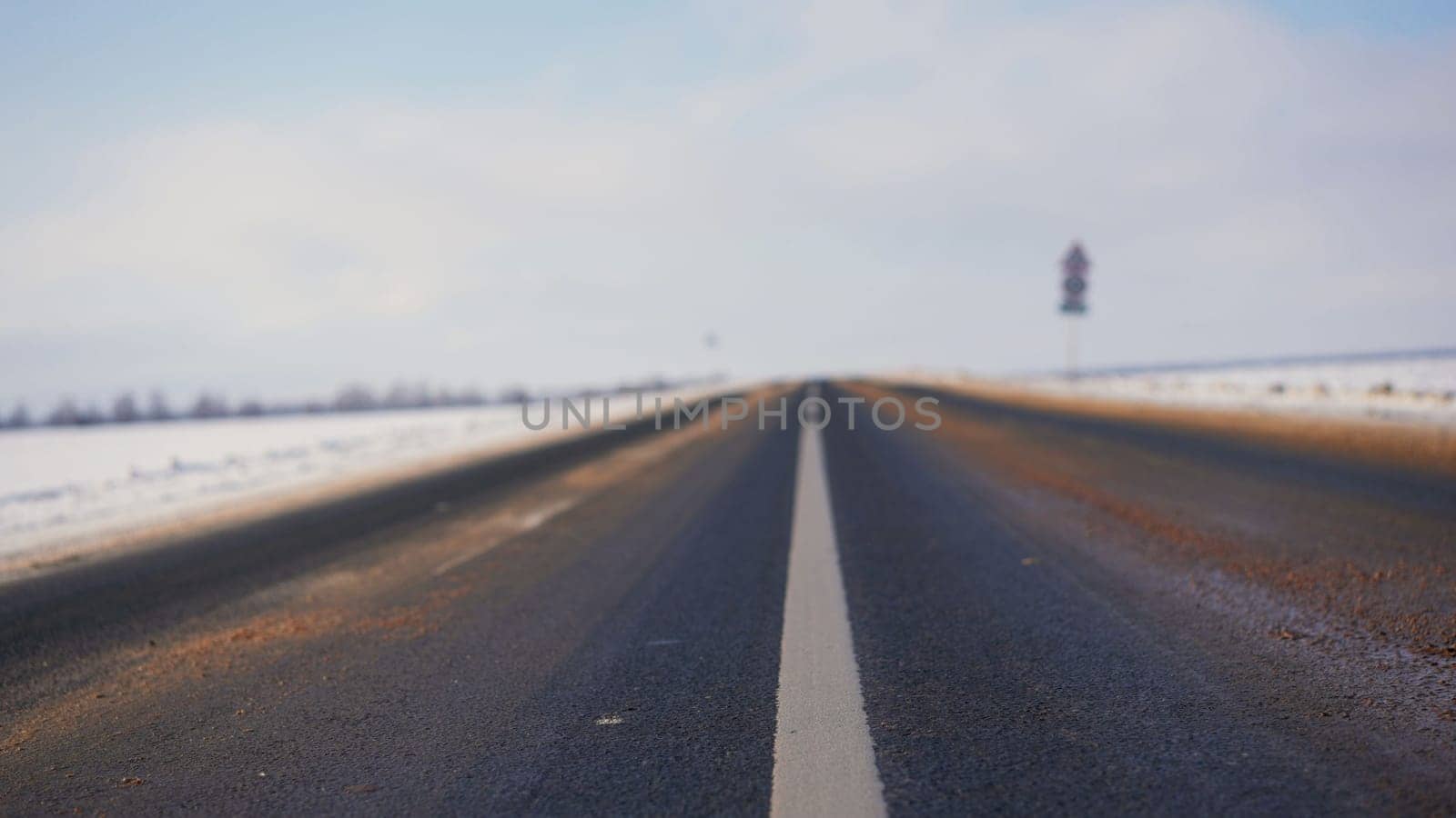Asphalt in winter. Winter background of the foreground of the road with white markings.