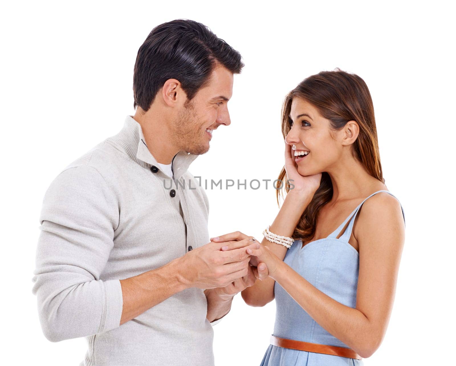 Happy, couple and ring with engagement news, announcement and yes to commitment and marriage. Proposal, surprise and smile in studio with love, jewelry and romance with white background and question.