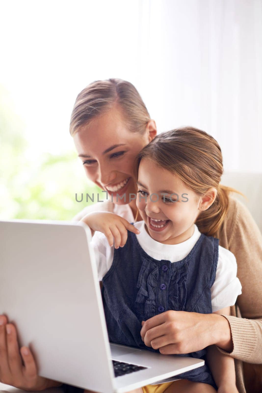 Laptop, education or laughing with mother and daughter on sofa in living room of home to study together. School, remote elearning or funny with woman parent and girl child in apartment for growth by YuriArcurs