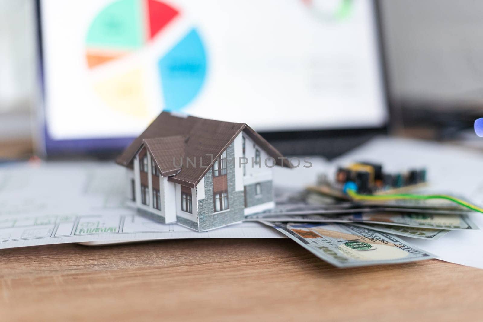 Model house on top of money pile suggesting savings for a house. High quality photo