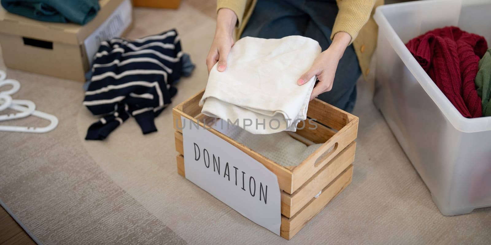 Donation, asian young woman sitting pack object at home, putting on stuff into donate box with second hand clothes, charity helping and needy people. Reuse recycle by nateemee