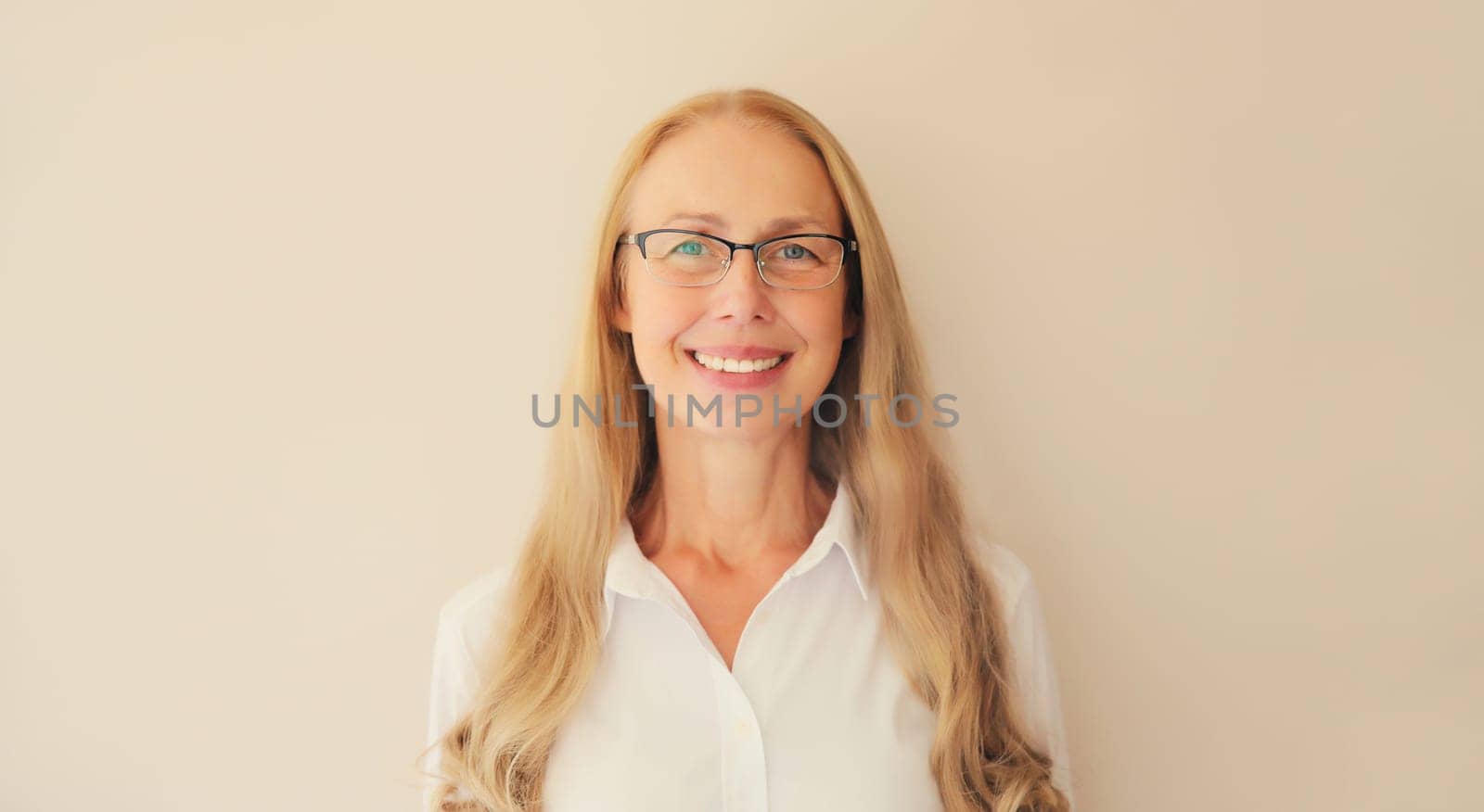 Portrait of happy smiling caucasian middle aged woman employee manager in eyeglasses and looking at camera in office at work or home