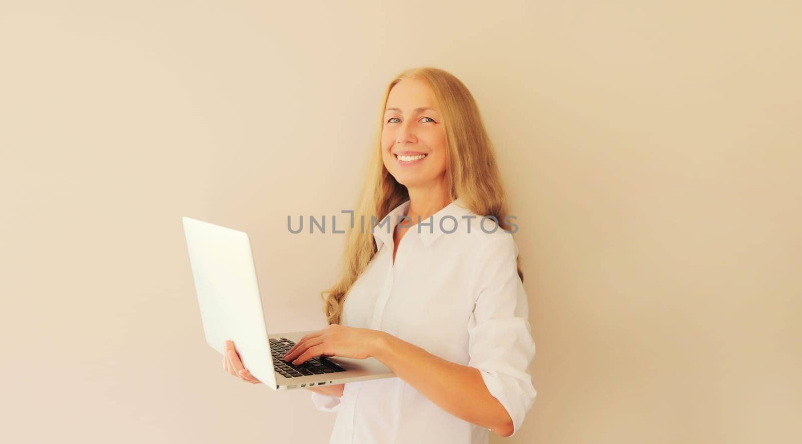 Happy caucasian middle-aged woman working with laptop at home by Rohappy