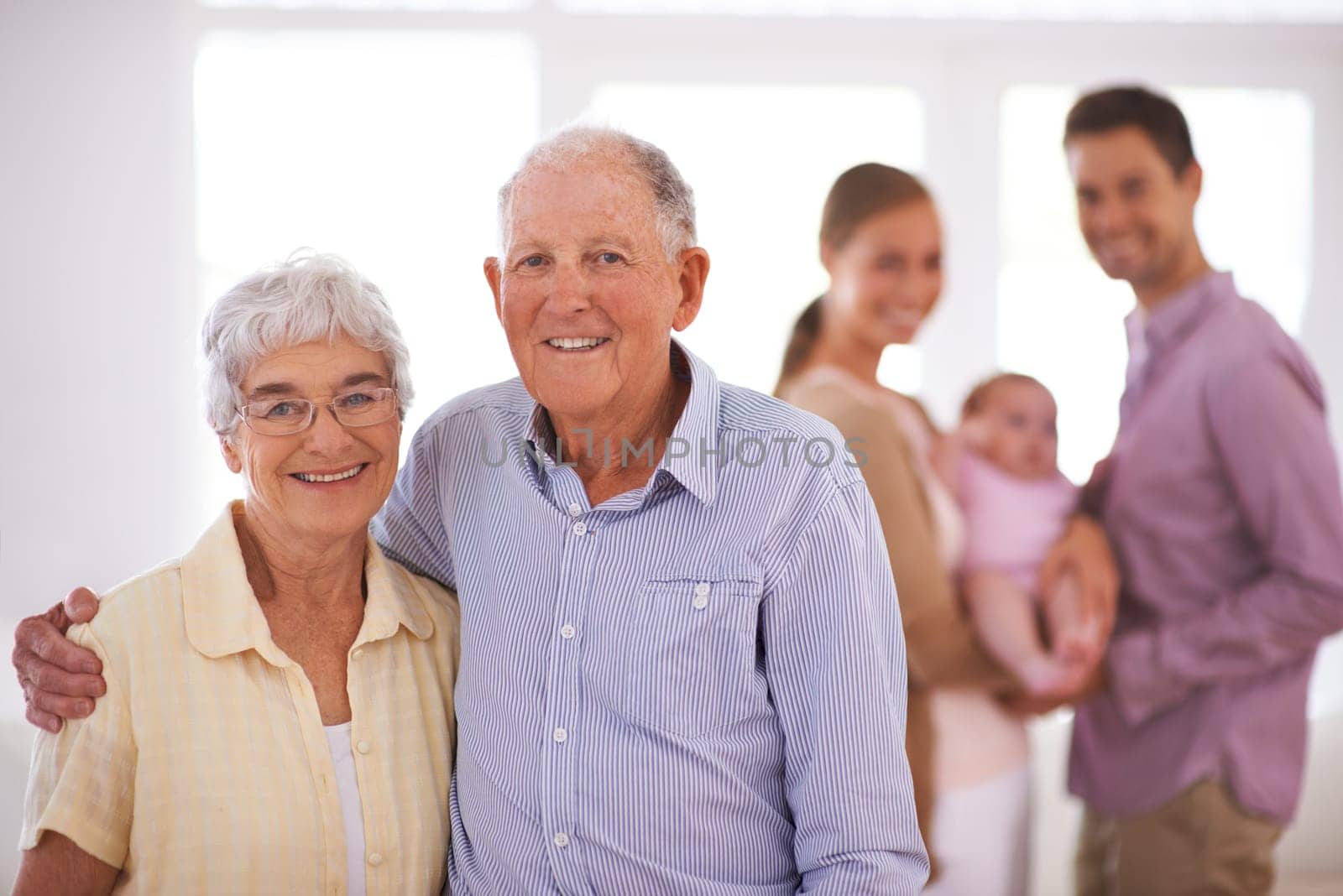Senior, couple and happy portrait in home with hug, family and commitment to marriage in living room. Elderly, man and woman with face, smile and embrace in lounge of house for romance, love or care.