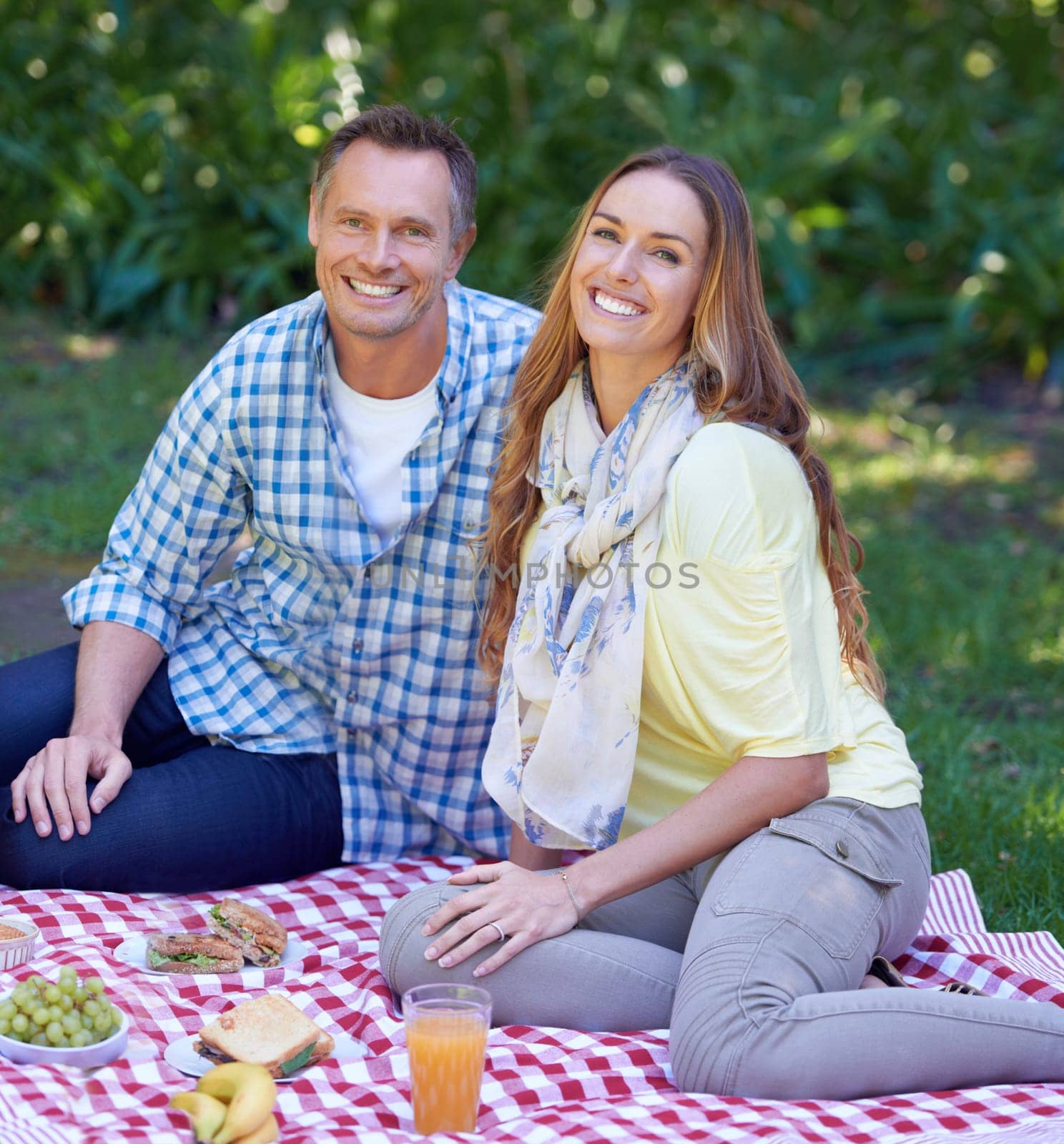 Portrait, picnic and couple with love, smile and happiness with romance and Valentines day with marriage. Outdoor, man or woman on the ground, relationship or anniversary with celebration or vacation.