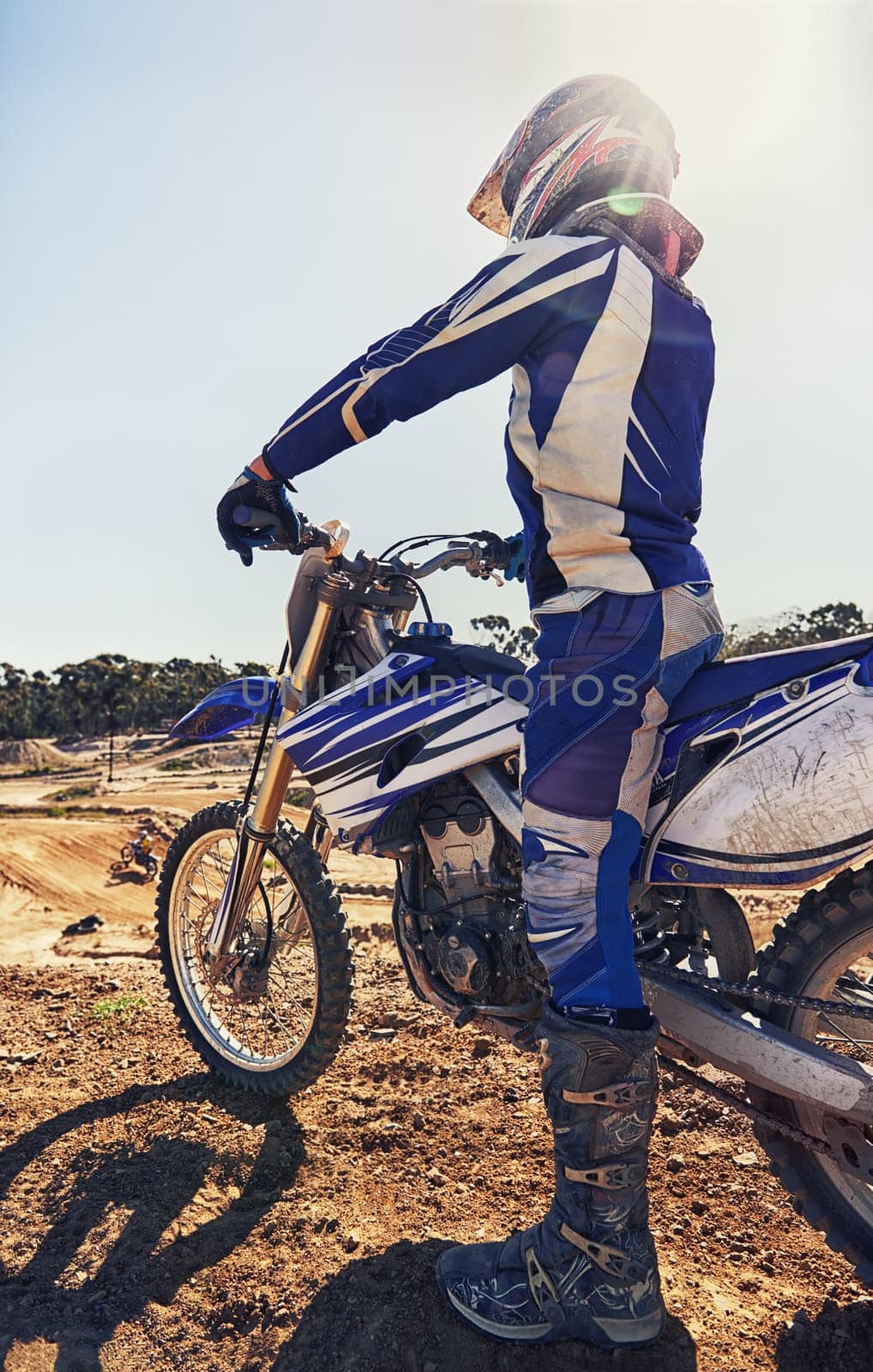 Motorcycle, extreme sports and danger with biker person outdoor, sunshine with uniform for riding on dirt track. Speed, power and risk with motorbike, transportation and adventure for adrenaline by YuriArcurs