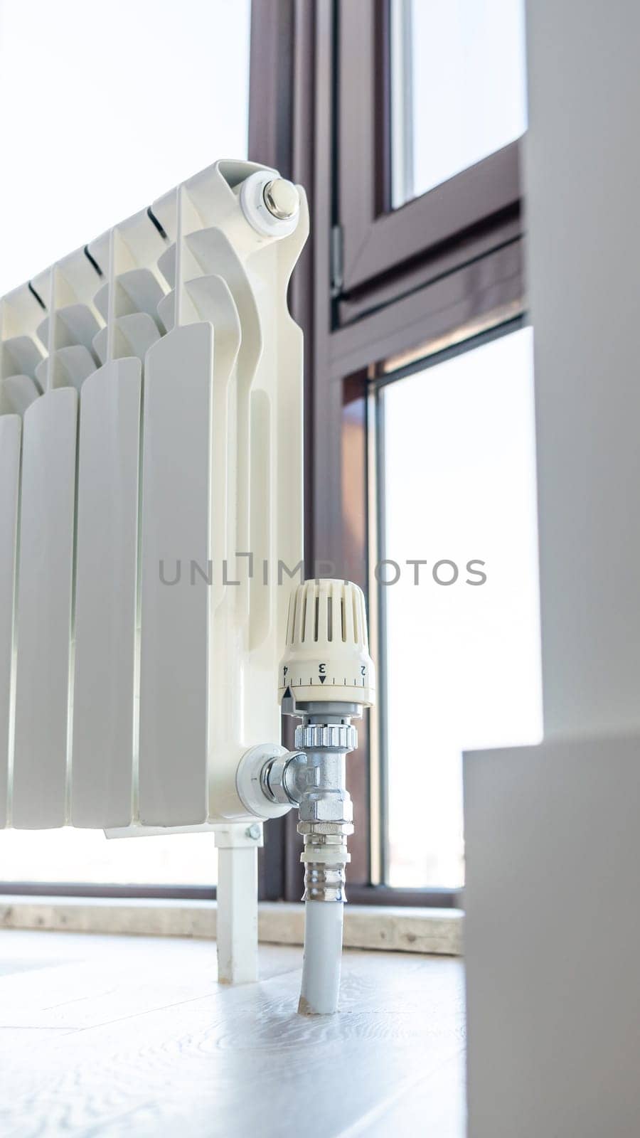 White big radiator near window in modern room by Mariakray