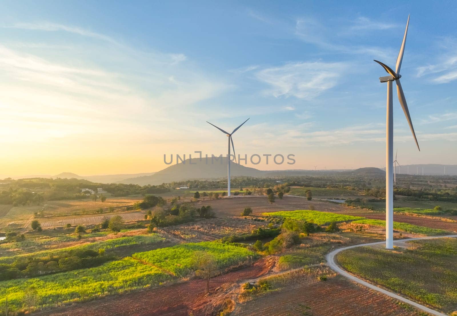 Wind farm field and sunset sky. Wind power. Sustainable, renewable energy. Wind turbines generate electricity. Sustainable development. Green technology for energy sustainability. Eco-friendly energy. by Fahroni