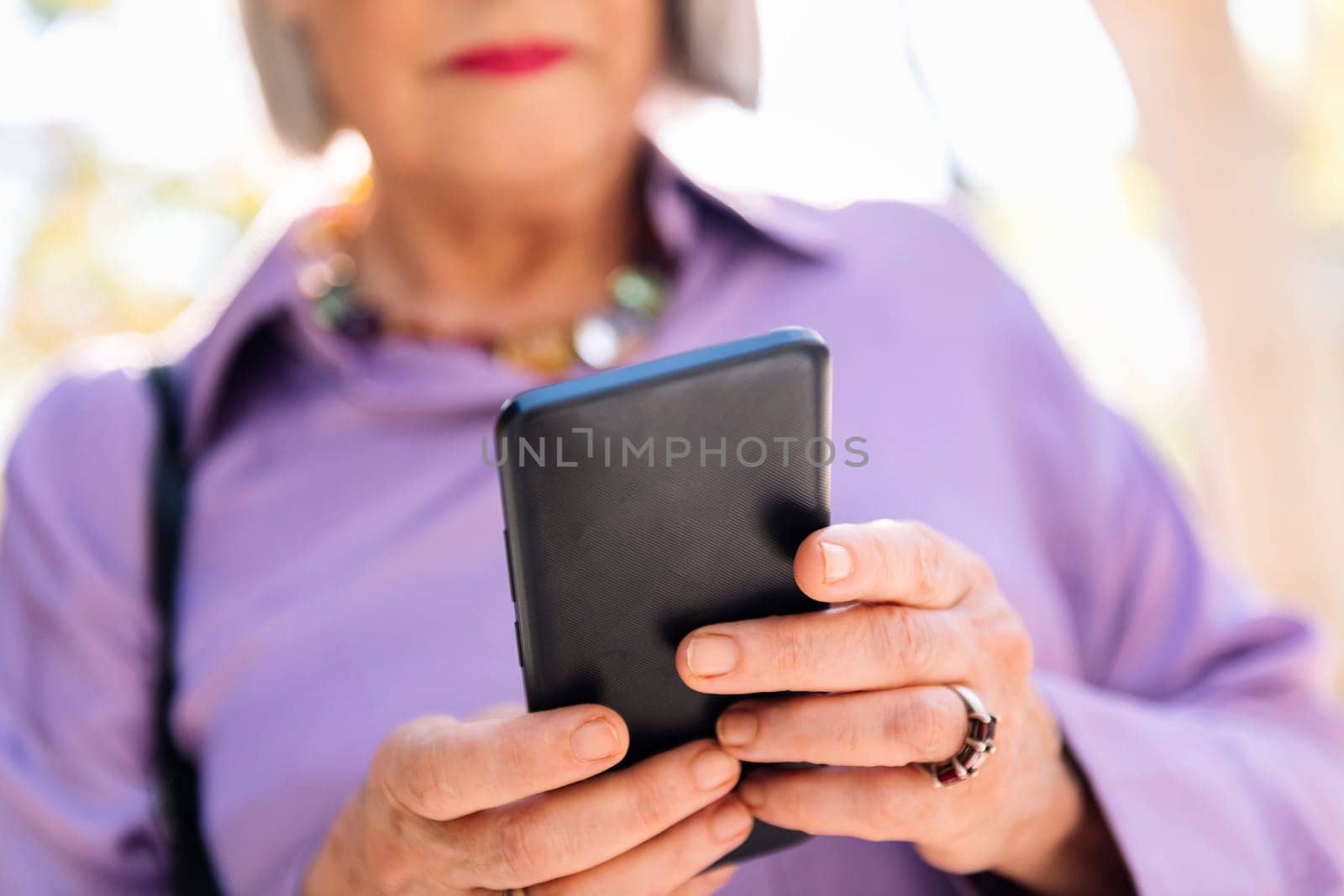 unrecognizable senior woman using mobile phone by raulmelldo