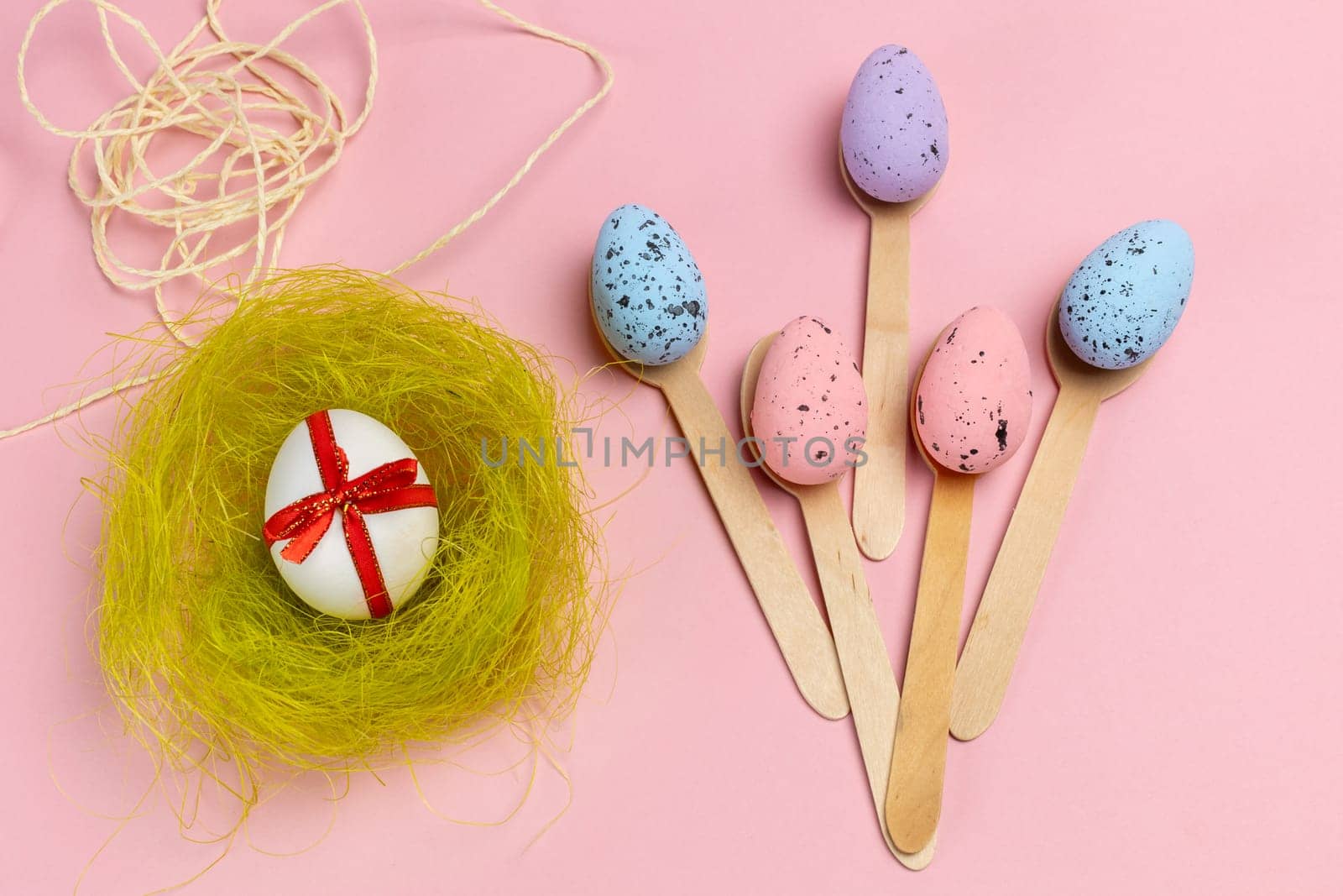 Colored Easter eggs with wooden spoons and a nest. by mvg6894