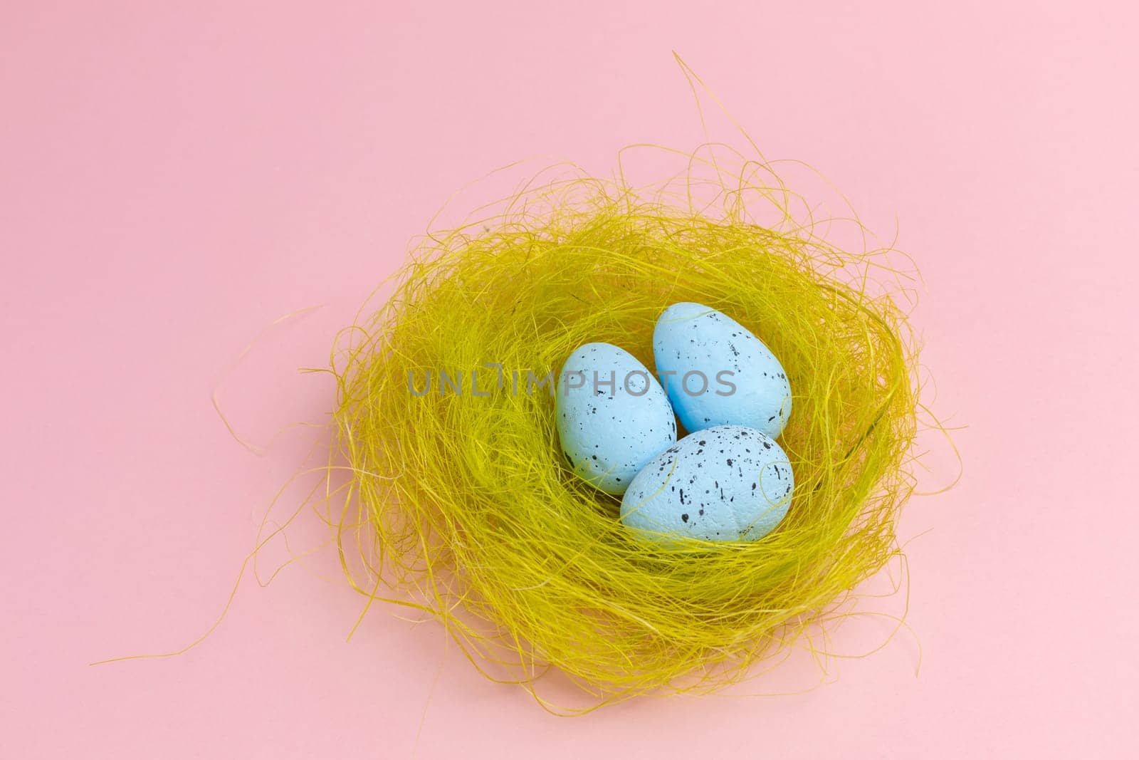 Nest with colored Easter eggs on the pink background. by mvg6894