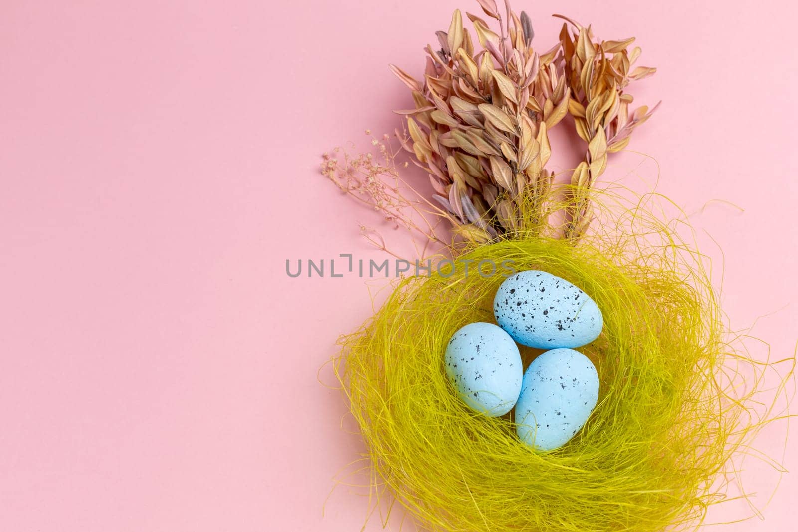 Nest with colored Easter eggs on the pink background. by mvg6894