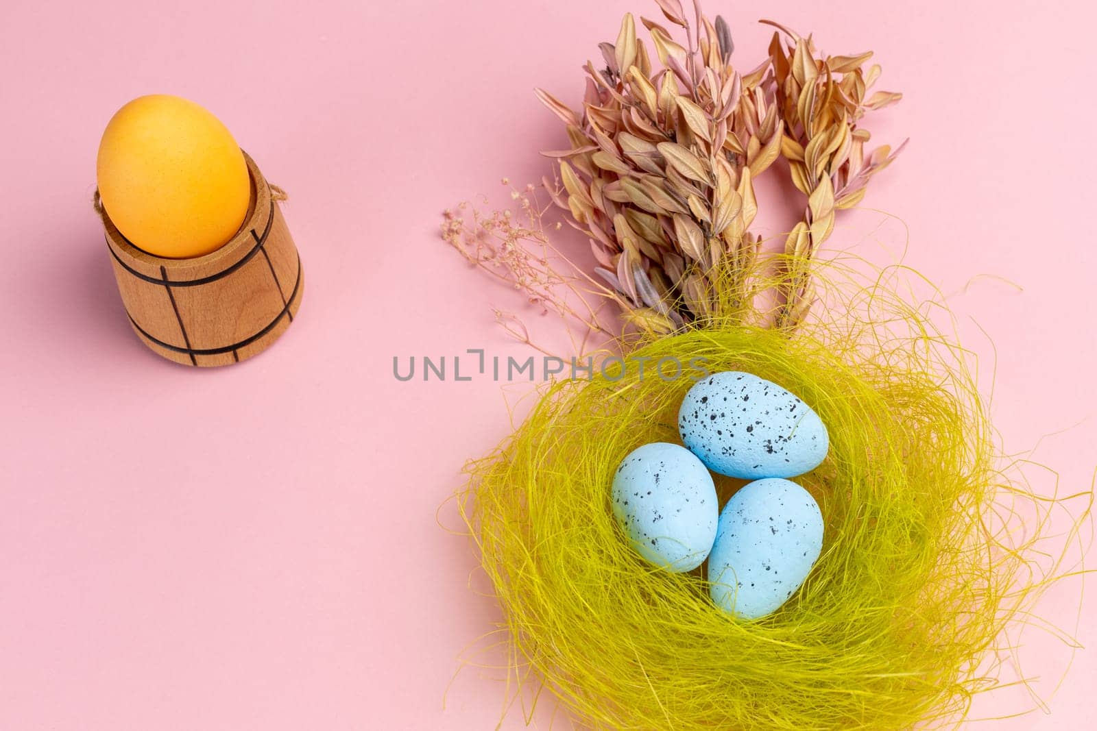Nest with colored Easter eggs on the pink background. by mvg6894
