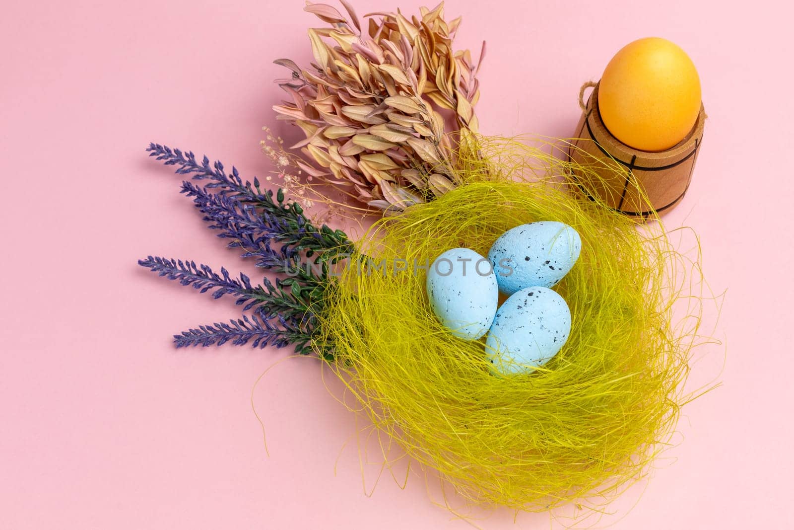 Nest with colored Easter eggs on the pink background. by mvg6894