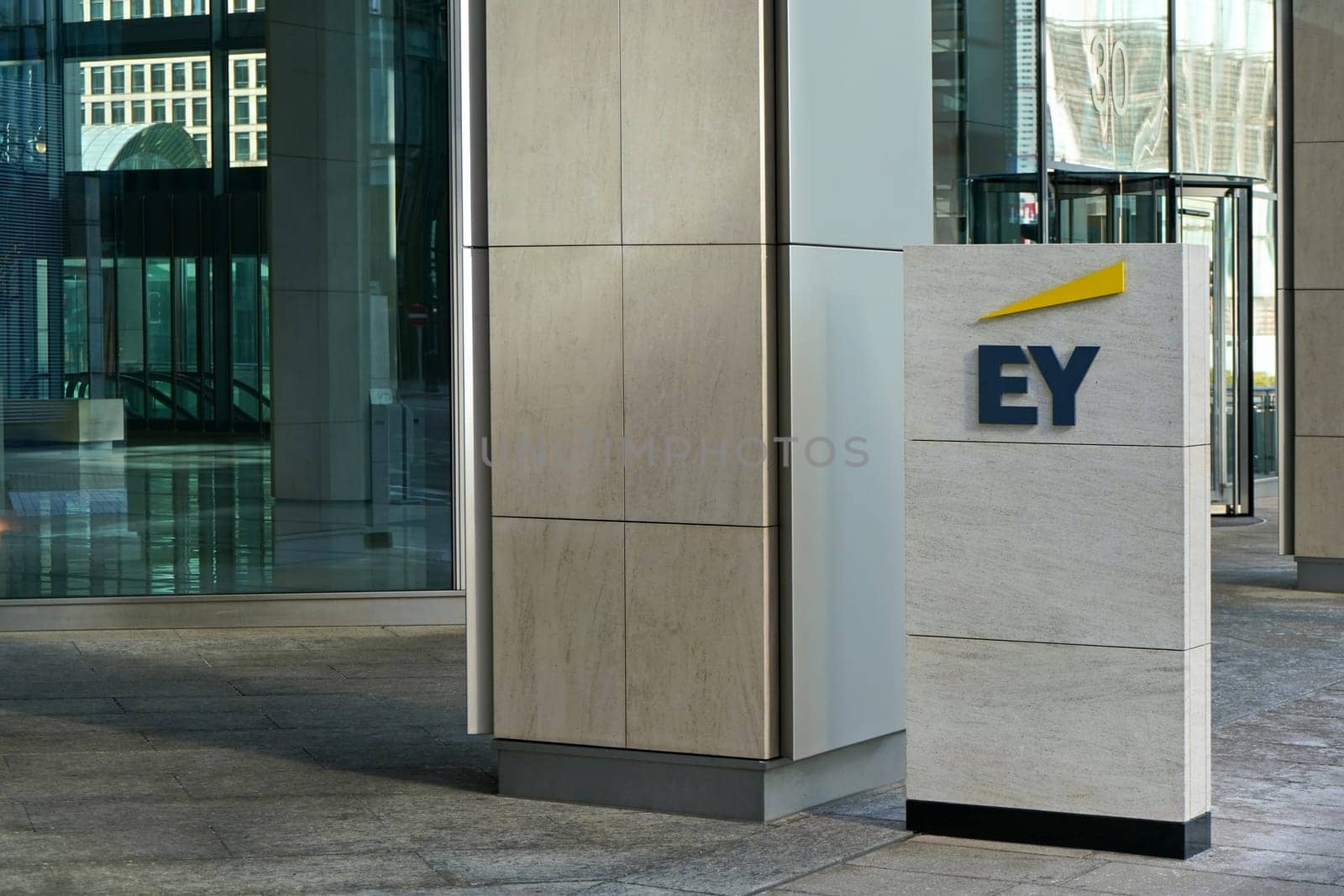 London, United Kingdom - February 03, 2019: Blue and yellow EY signage at entrance to their office in Canary Wharf. It is UK professional services company, one of big 4 accounting firms by Ivanko
