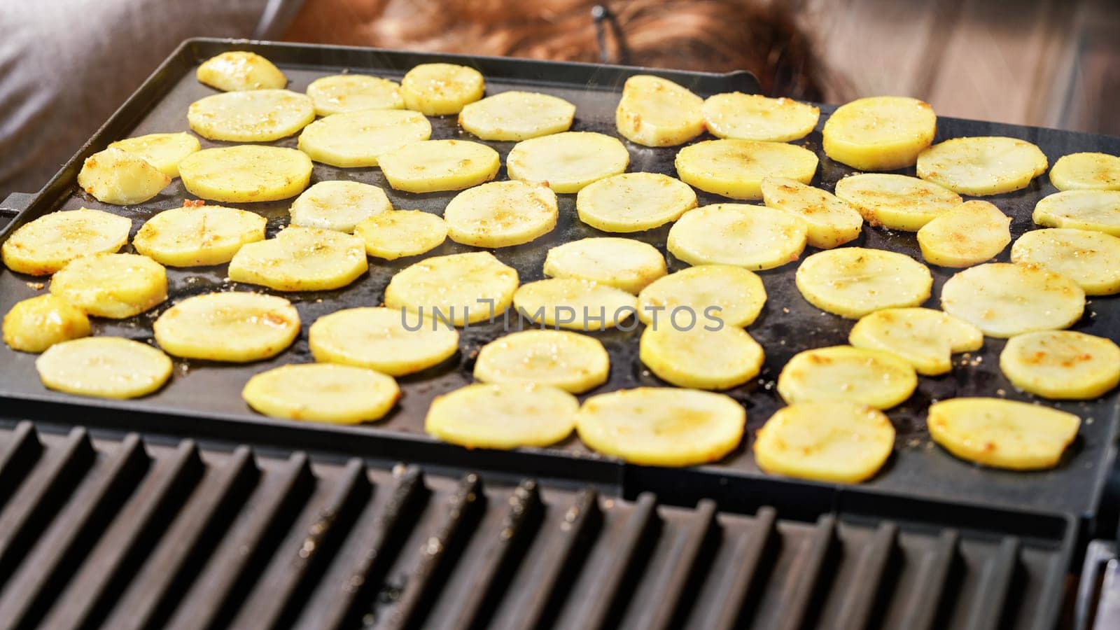 Potato sliced to small circles, seasoned with spice, grilled on electric grill by Ivanko