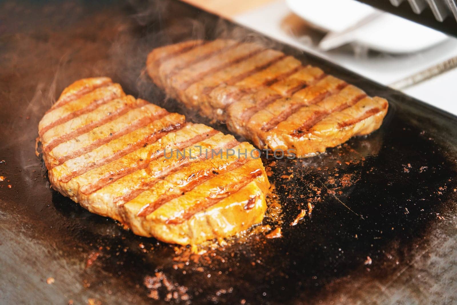 Two pork cutlets steaks grilled on electric grill by Ivanko