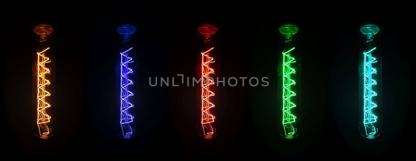 Retro looking light bulb glowing on dark background, bright wire visible in glass - colour can be changed with hue / saturation tool