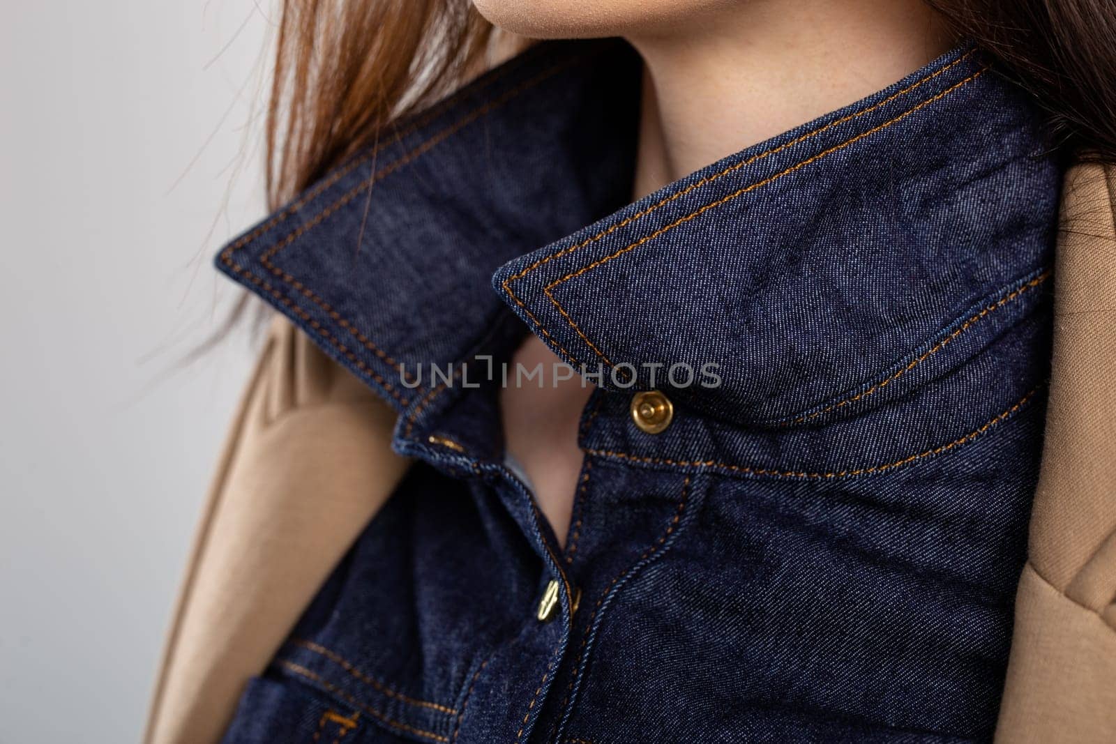 Close-up of a blue denim shirt collar with a brown corduroy jacket lapel. Shirt is buttoned up, collar turned up, and jacket open.