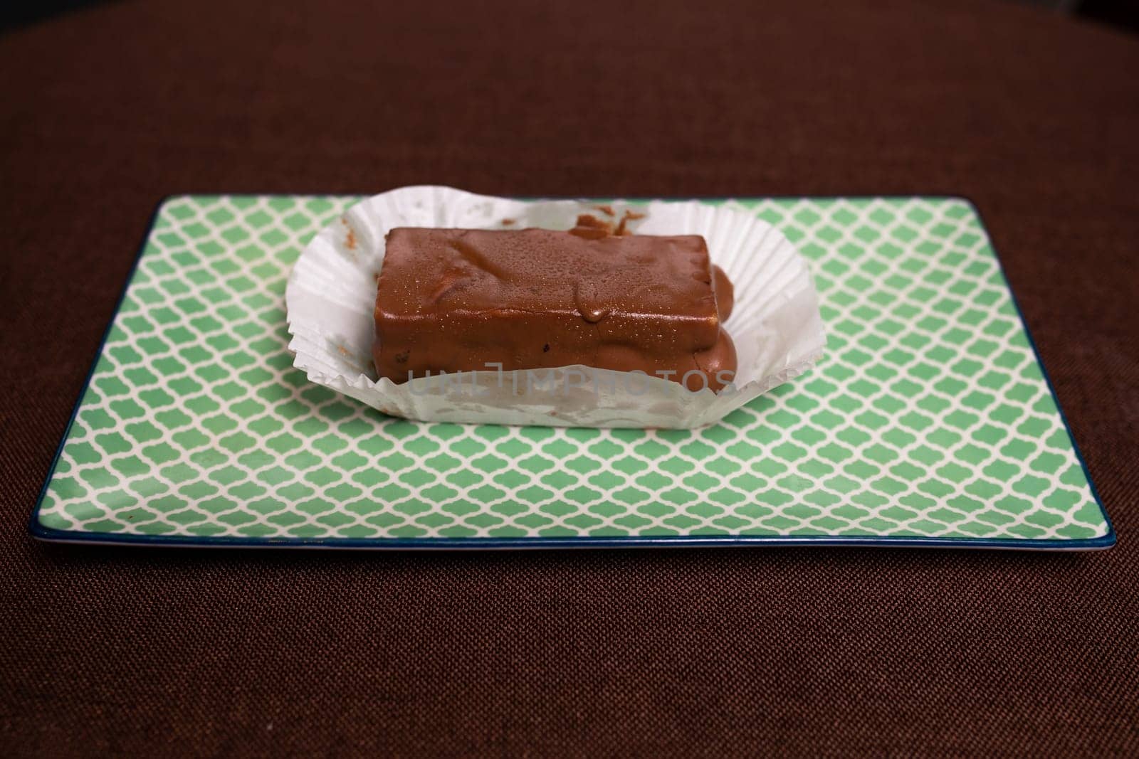 Rich and decadent chocolate fudge, highlighted on a light green background. chocolate dessert. by Pukhovskiy